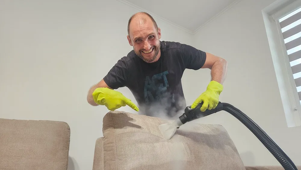Specialist CleanSpot curățând tapițeria unei canapele cu abur în Oradea